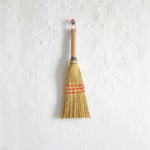 Wood hand broom with red stitching